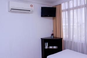 马六甲Queenspark Lovita Hotel的客房设有床、电视和窗户。