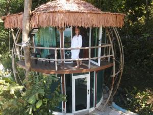 珍南海滩MyRus Resort Langkawi的站在圆树屋中的女人