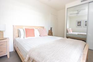 金斯克里福Dune Beachfront Apartments by Kingscliff Accommodation的卧室配有一张白色大床和镜子