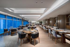 长沙长沙雅诗阁湘江财富金融中心服务公寓的餐厅设有桌椅和大窗户。