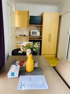 努里乌特帕巴罗莎旅游汽车旅馆的一张桌子,上面有黄色花瓶,上面有鲜花