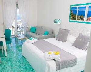 卡普里Relais Maresca Luxury Small Hotel的酒店客房,设有两张床和一张沙发