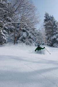 山之内町AIBIYA的一个人在雪覆盖的斜坡上滑雪