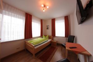 哥达帕松姆奥斯巴霍夫旅馆的卧室配有一张床、一张书桌和窗户。