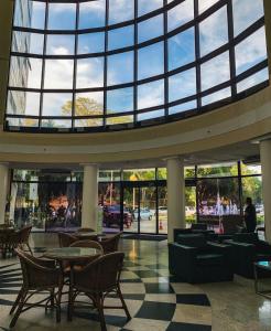 马瑙斯Tropical Executive Hotel Flats的大堂设有桌椅和大窗户。