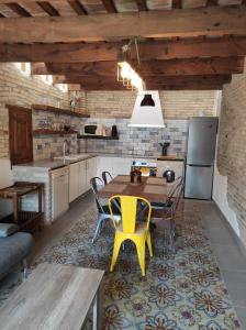 代尔特布雷Casa Rural MESTRE的厨房配有木桌和黄色椅子