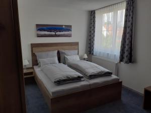 莱奇根Landgasthof Hotel Lamm的卧室配有带枕头的床铺和窗户。