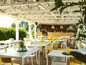 RaszowaHotel Magiczny Zakątek的餐厅设有白色的桌子和黄色的椅子