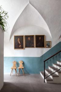 博尔扎诺Goldenstern Townhouse的墙上有三幅画像的房间,有两张桌子
