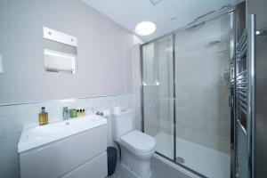 索尔兹伯里梨树服务式公寓的一间带卫生间和玻璃淋浴间的浴室