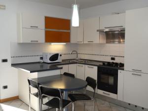 卡尔多纳佐Apartment Schmid by Interhome的厨房配有白色橱柜和桌椅