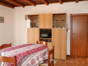 卡尔多纳佐Apartment Brida by Interhome的一间卧室配有一张床和一个木制橱柜