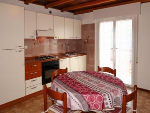 卡尔多纳佐Apartment Brida by Interhome的一间带桌子的厨房和一间带白色橱柜的厨房