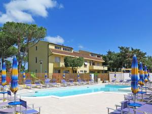 切齐纳码头Apartment Riviera 5 by Interhome的一个带蓝色和黄色遮阳伞及椅子的游泳池