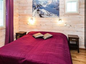 ValkeinenHoliday Home Alppituulahdus 10a by Interhome的一间卧室配有一张紫色床和两个枕头