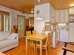 KukkolaHoliday Home Sammal by Interhome的厨房以及带木桌和椅子的用餐室。
