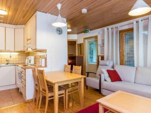 Kukkola拉希卡迪瓦德玛度假屋的厨房以及带桌子和沙发的客厅。