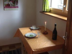 昆塔尔Apartment Chalet Zimmermann by Interhome的一张带蜡烛和一瓶葡萄酒的桌子