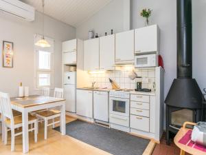 拉赫登佩拉Holiday Home Prokatti by Interhome的厨房配有白色橱柜、桌子和炉灶。