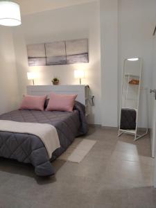 罗萨里奥港Casa Guanche的一间卧室配有一张带粉红色枕头的床和梯子
