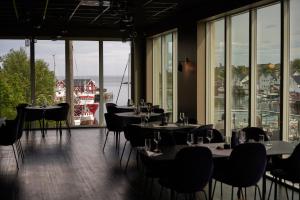 索尔瓦根The Tide - Hotel的餐厅设有桌椅和大窗户。