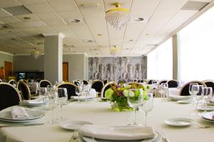 比亚雷亚尔Hotel Vila-real Azul的一间会议室,配有长桌子、眼镜和椅子