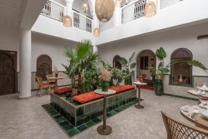 马拉喀什Riad Babouchta & Spa的大堂配有沙发、桌子和植物
