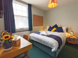布莱顿霍夫The Stirling Arms Pub & Rooms的一间卧室配有蓝色和黄色枕头的床