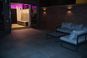 斯赫拉芬赞德Royal Suite的紫色灯砖墙上的沙发和凳子