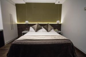 巴塞罗那现代酒店的一间卧室配有一张带绿色墙壁的床