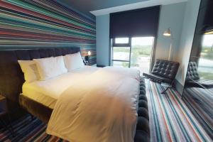 法恩伯勒法恩伯勒乡村酒店的一间卧室设有一张带条纹墙的大床