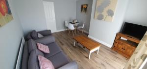 斯坦福德Stamford - Entire 1 bed cosy home.的客厅配有灰色的沙发和桌子