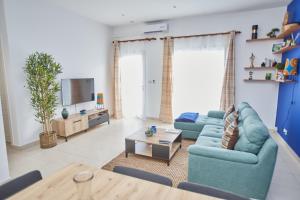 黑角Superbe vue sur océan的客厅配有2张蓝色沙发和电视