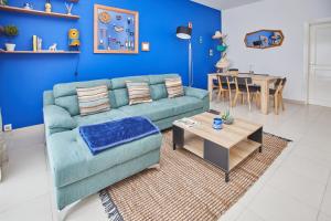 黑角Superbe vue sur océan的客厅配有蓝色的沙发和桌子