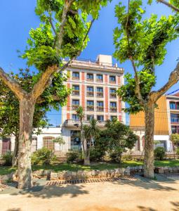 卡里拉30º Hotels - Hotel Espanya Calella的前面有树木的建筑