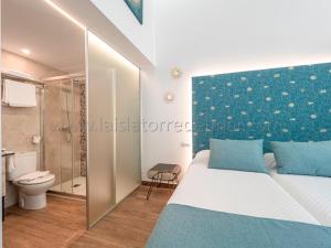 托雷德尔马尔La Isla , tu hogar en Torre del Mar.的一间卧室设有一张床、一个卫生间和淋浴。