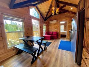 CarrollB1 NEW Awesome Tiny Home with AC Mountain Views Minutes to Skiing Hiking Attractions的厨房以及带桌子和冰箱的客厅。