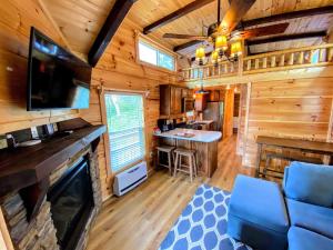 CarrollB2 NEW Awesome Tiny Home with AC Mountain Views Minutes to Skiing Hiking Attractions的小木屋内设有一间带电视的客厅和一间酒吧