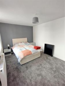 蒂斯河畔斯托克顿Yarm Lane Apartments - Stockton Town Centre的一间卧室配有一张床和一台平面电视