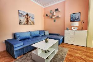 索非亚Colorful apartment的客厅配有蓝色的沙发和桌子