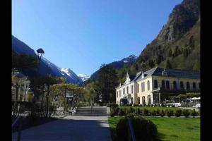 科特雷Chaleureux studio familal en centre ville avec vue sur les montagnes的一座白色的大建筑,背景是群山