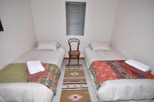 莫塞尔湾Cyprus Manor 12的配有椅子的客房内的两张单人床