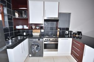 莫塞尔湾Cyprus Manor 12的厨房配有白色橱柜和洗衣机。