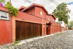 墨西哥城La Casita de Coyoacán的红砖建筑,设有木制车库门