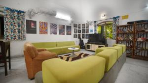 浦那Hostel Lifespace- Garden Bungalow with Pods, CoWork & Cafe的客厅设有黄色沙发和电视