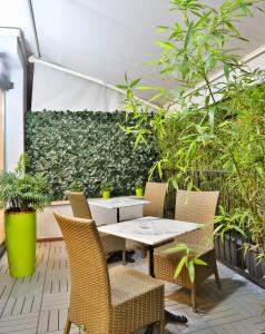 米兰Hotel Astoria Sure Hotel Collection By Best Western的种有植物的庭院里的桌椅