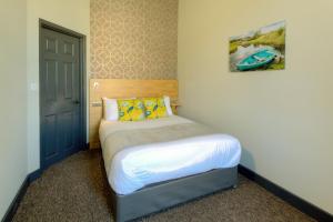 大雅茅斯Remaotel Seafield Court Apartments的一间小卧室,配有一张带黄色枕头的床