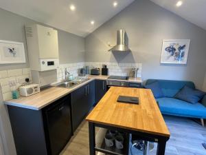 West BradfordBeautiful self-catering cottages, Ribble Valley的厨房配有桌子和蓝色沙发