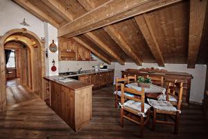 奥伦佐卡多利Appartamento Mainardi的厨房配有桌子和一些木橱柜