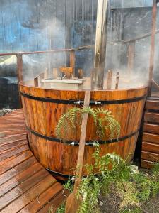 梅利佩乌科Hostal siete colores, Melipeuco的木制浴缸位于木甲板上